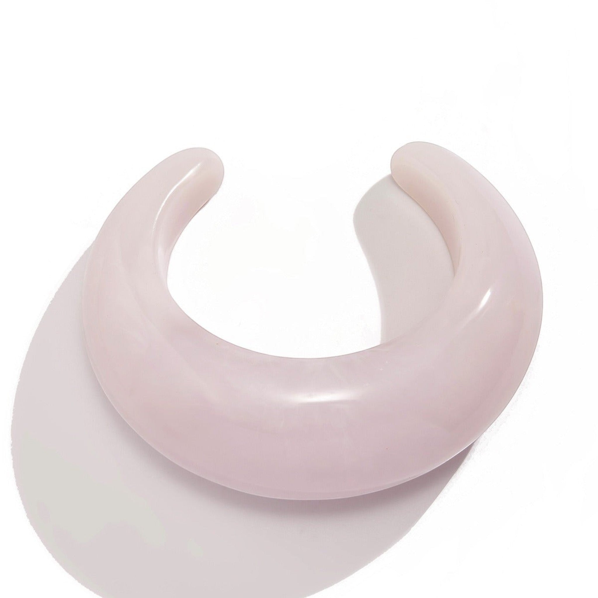 Tania Claire Australia Billy Bangle, a light pink, polished resin cuff bracelet with a curved, open design.