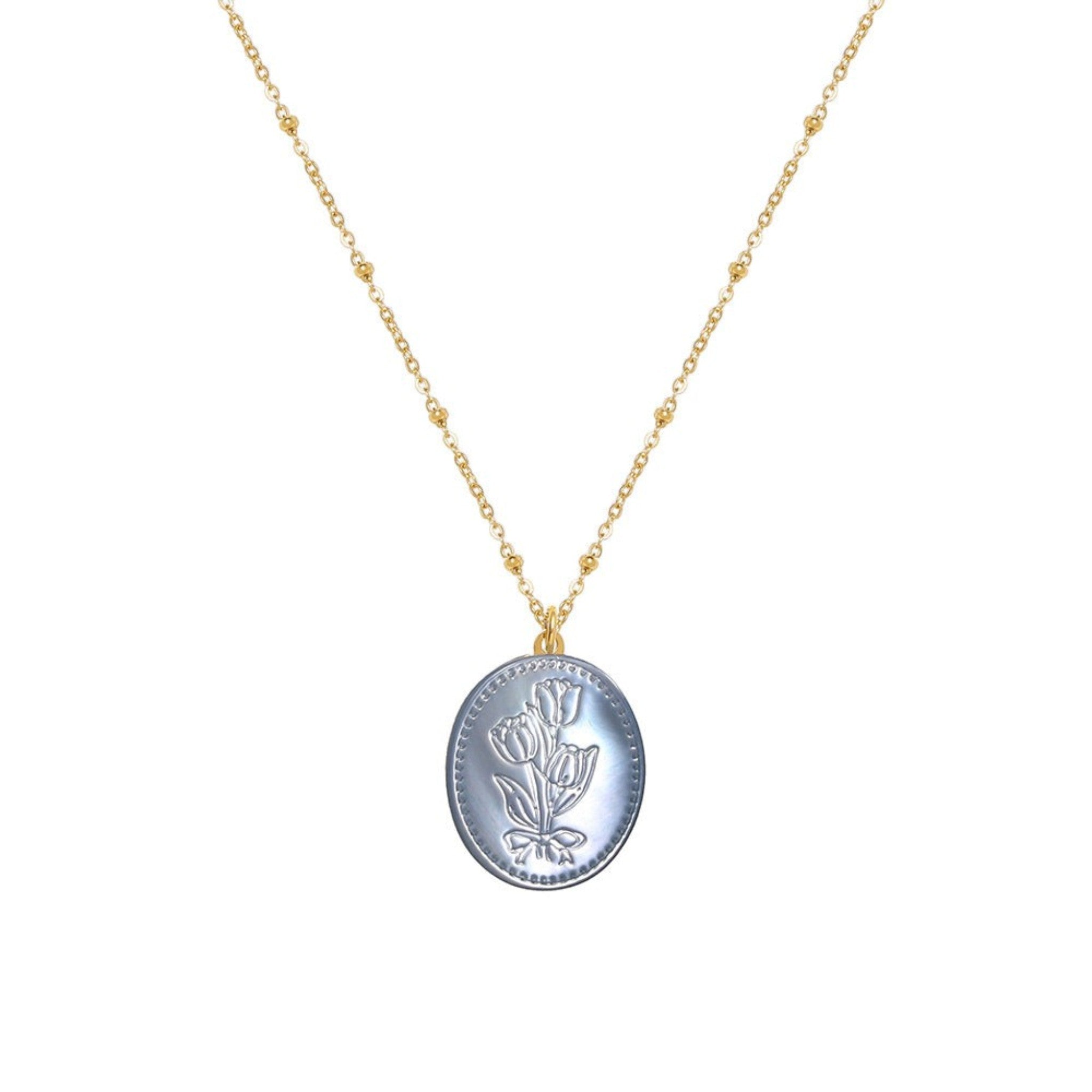 Tania Claire Australia Flora Necklace: gold-plated chain with bead accents and oval pendant featuring embossed floral motif in pastel blue.