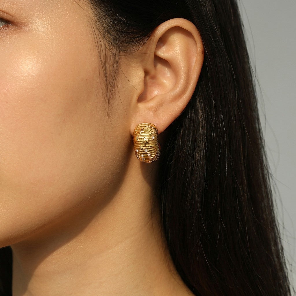 Tania Claire Australia gold-plated textured galaxy hoop earrings with cubic zirconia stones.