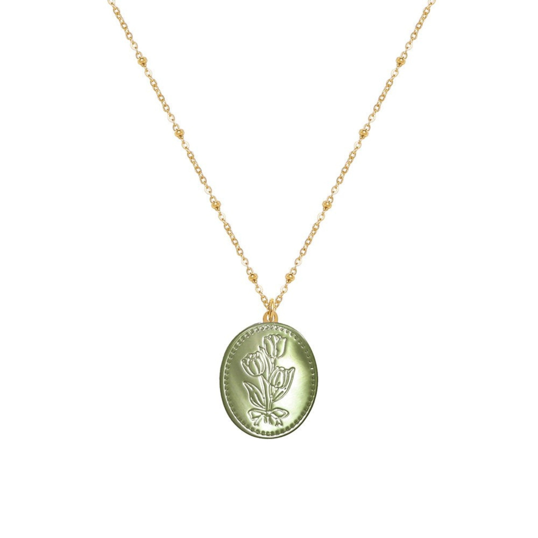 Tania Claire Australia green oval pendant necklace with embossed floral motif and beaded gold-plated chain.