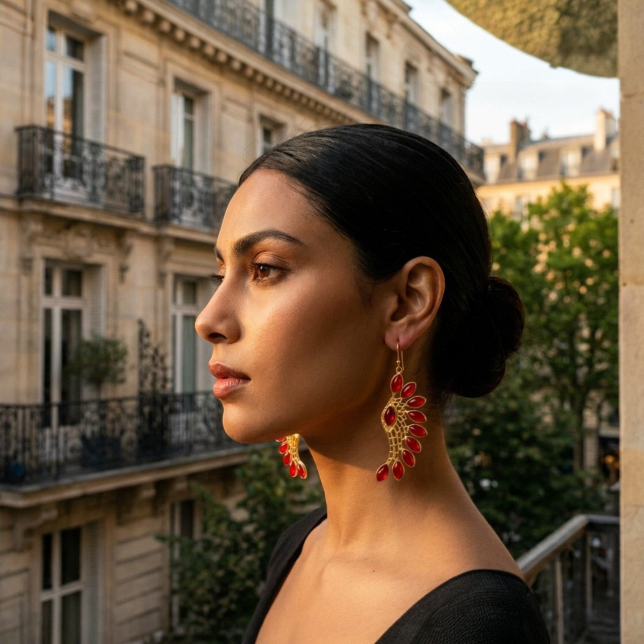 Tania Claire Australia sculptural gold-tone phoenix wing earrings with red marquise-cut garnets.