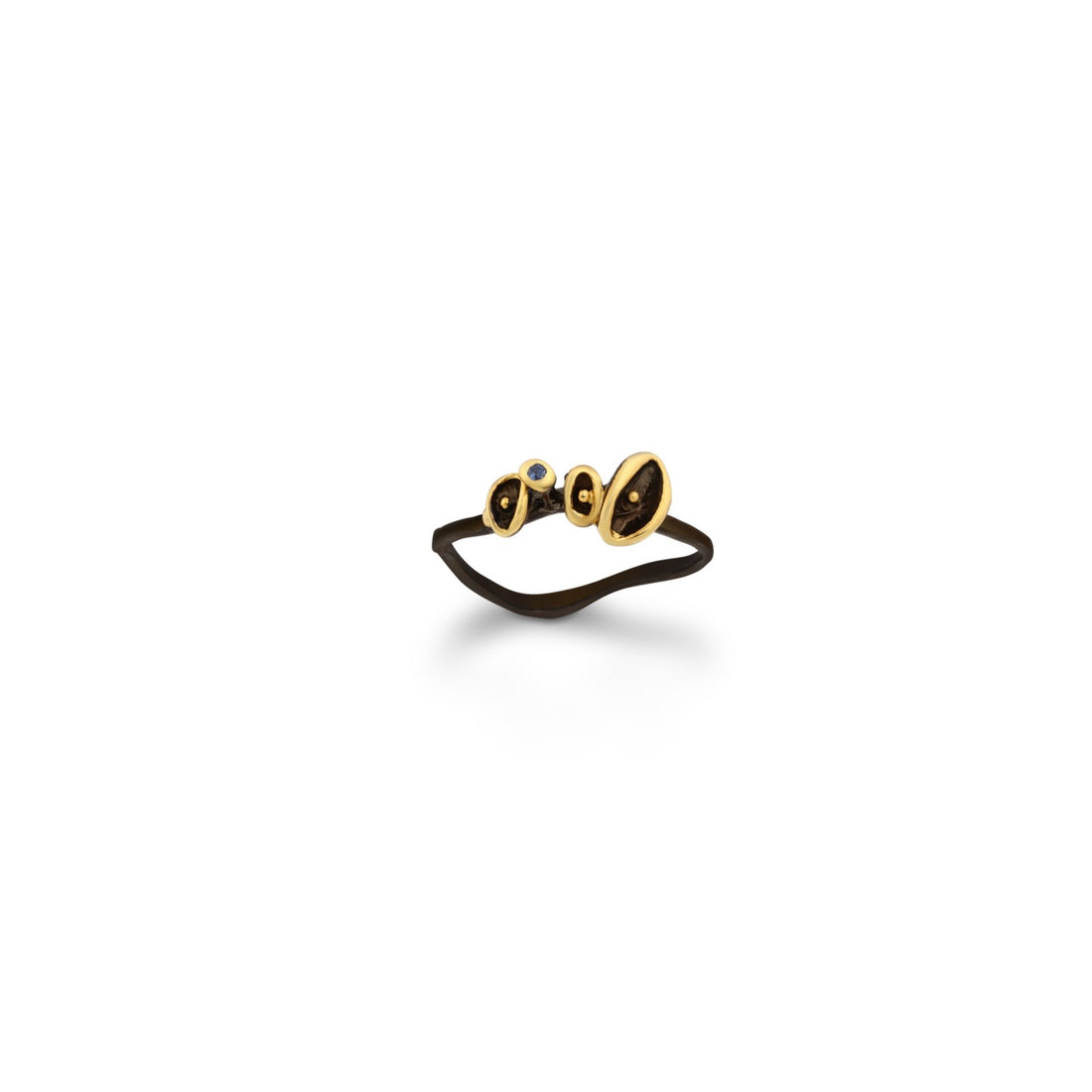 A sterling silver ring plated with 3 microns of 22K yellow gold, featuring black rhodium accents and a blue sapphire gemstone.