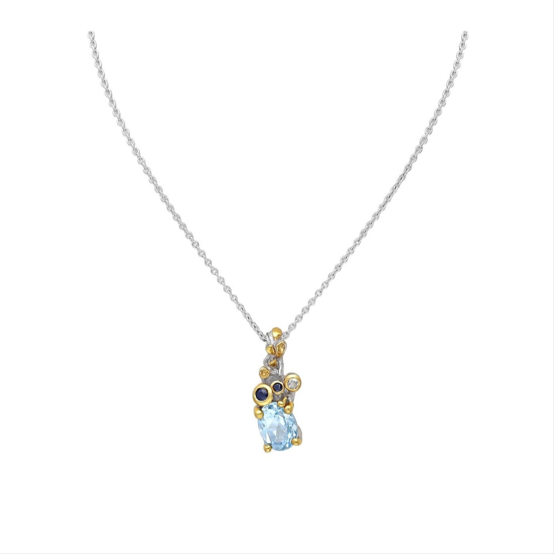 A sterling silver necklace with a 22K yellow gold plate and a drop-shaped sky blue topaz pendant, accompanied by small round blue sapphire gemstones.
