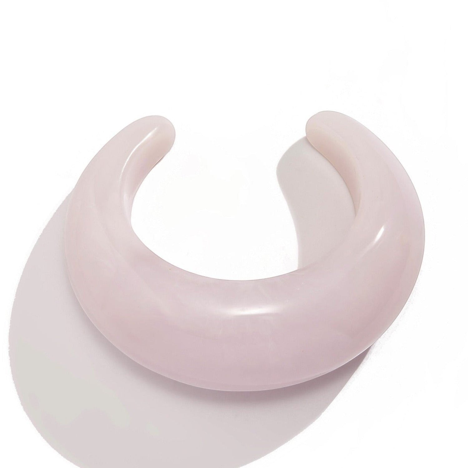 Tania Claire Australia Billy Bangle, a light pink, polished resin cuff bracelet with a curved, open design.