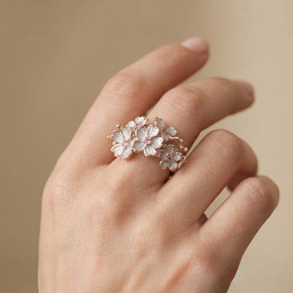 Tania Claire Australia Blossom Ring: Sterling silver floral ring with white enamel petals, pink sapphires, and rose gold accents.