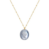 Tania Claire Australia Flora Necklace: gold-plated chain with bead accents and oval pendant featuring embossed floral motif in pastel blue.