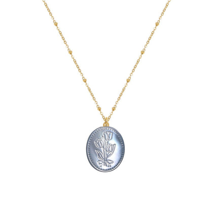 Tania Claire Australia Flora Necklace: gold-plated chain with bead accents and oval pendant featuring embossed floral motif in pastel blue.