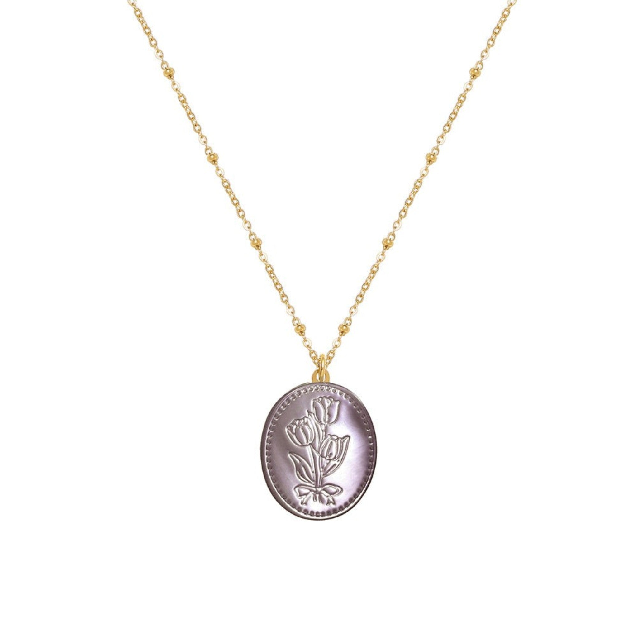 Tania Claire Australia Flora Necklace: gold-plated chain with bead accents and oval pendant featuring embossed floral motif and bow.