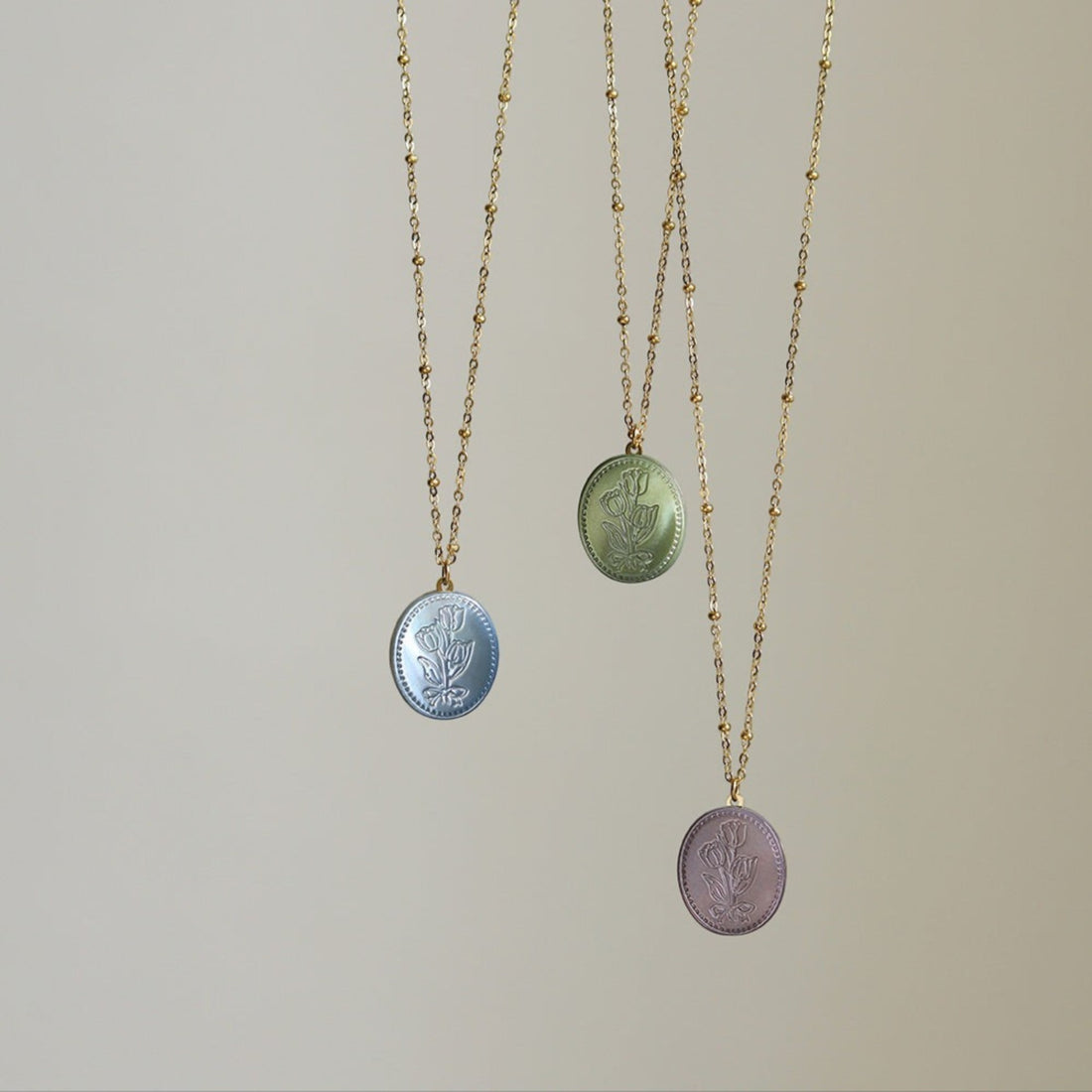 Tania Claire Australia Flora Necklace in blue, green, and lilac with floral motif pendant and beaded gold-plated chain.