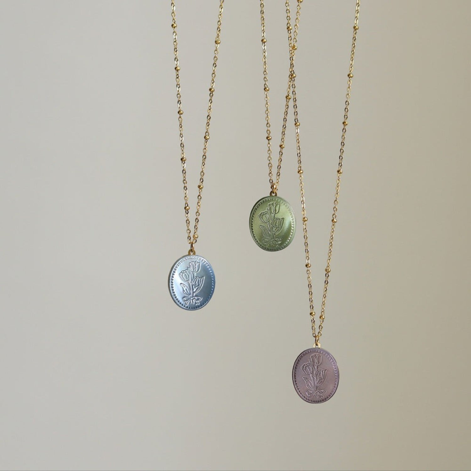 Tania Claire Australia Flora Necklace in blue, green, and lilac with floral motif pendant and beaded gold-plated chain.