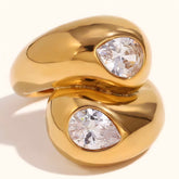 Tania Claire Australia gold bypass ring featuring two pear-cut clear stones in a polished chunky gold band design.