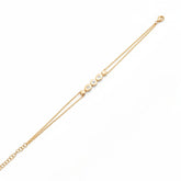 Tania Claire Australia gold double chain bracelet with five circular charms, three set with sparkling stones.