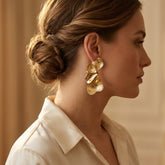 Tania Claire Australia Dryas Crest gold leaf earrings worn by a woman in profile, featuring sculptural ribbed texture.