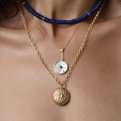 Tania Claire Australia 14K gold necklace with mother-of-pearl disc, sapphire, crystal, and linear bar design.
