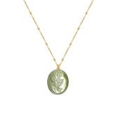 Tania Claire Australia green oval pendant necklace with embossed floral motif and beaded gold-plated chain.