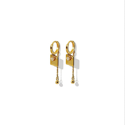 Tania Claire Australia gold-plated hoop earrings with square charm, cubic zirconia, and dangling chain with bead.
