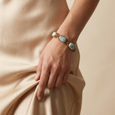 Tania Claire Australia Holly gemstone twist bracelet with blue cabochon stones and gold plating on a model&