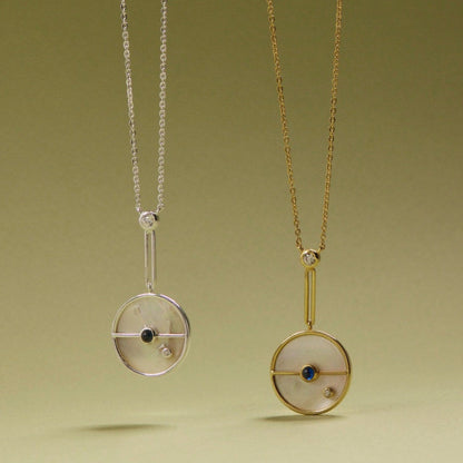 Tania Claire Australia Lunar Orbit Necklace: 14K gold, mother-of-pearl disc, sapphire, diamond accent. Elegant celestial design.