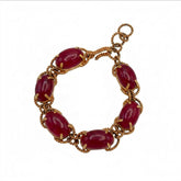 Tania Claire Australia gold-plated twist bracelet featuring deep red cabochon gemstones in a linked chain design.