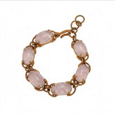 Tania Claire Australia gold-plated twist bracelet featuring oval cabochon rose quartz gemstones.