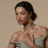 Tania Claire Australia Sacred Bloom earrings with garnet, peridot, and pearl on a model wearing a silk dress.