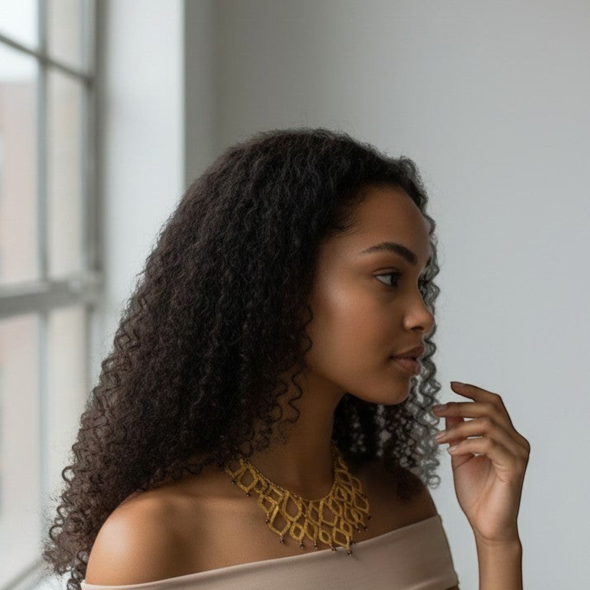 Tania Claire Australia Temple Flame necklace featuring architectural gold brass lattice and garnet gemstones on a model