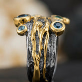 Tania Claire Australia Tidal Relic Ring featuring blue topaz and emerald in textured sterling silver and molten gold.